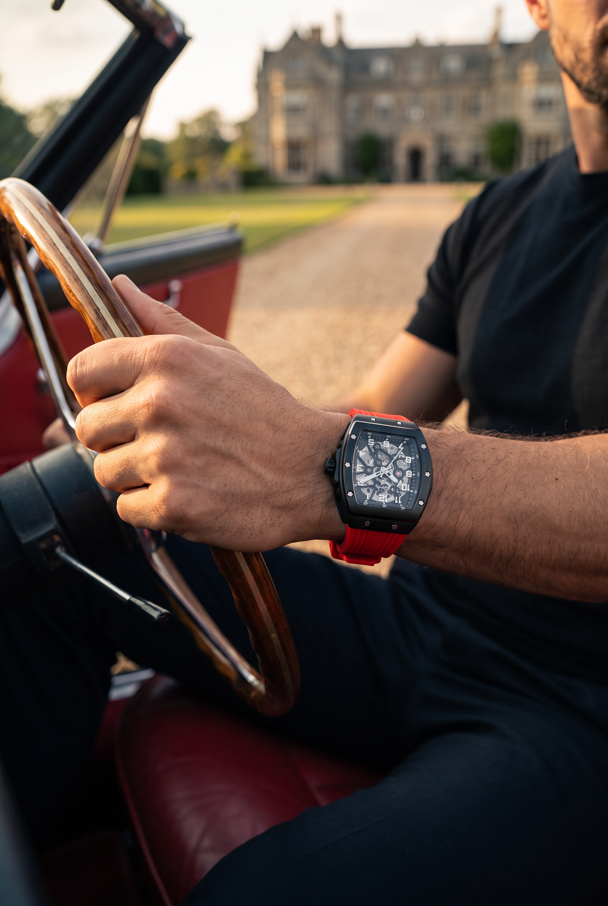 Millionaire horloge zwart met rode band - hand aan het stuur van een oldtimer bij landhuis