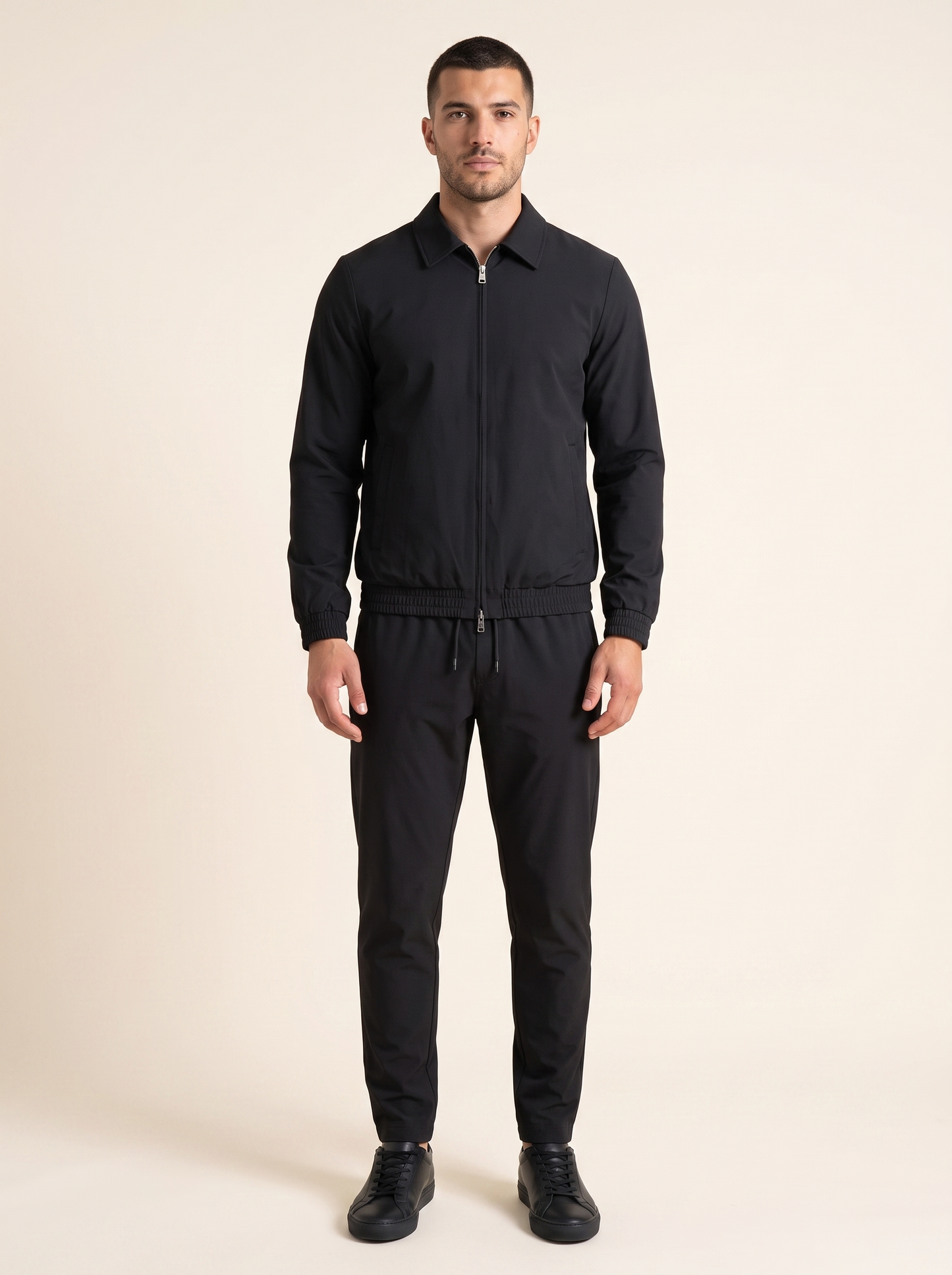 Tech suit zwart op model, vooraanzicht. Model is 1,89 m en draagt maat XL.