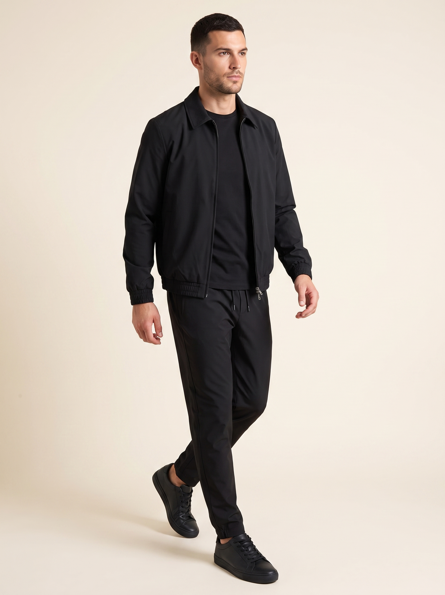 Tech suit zwart op model, driekwart met jack open. Model is 1,89 m en draagt maat XL.