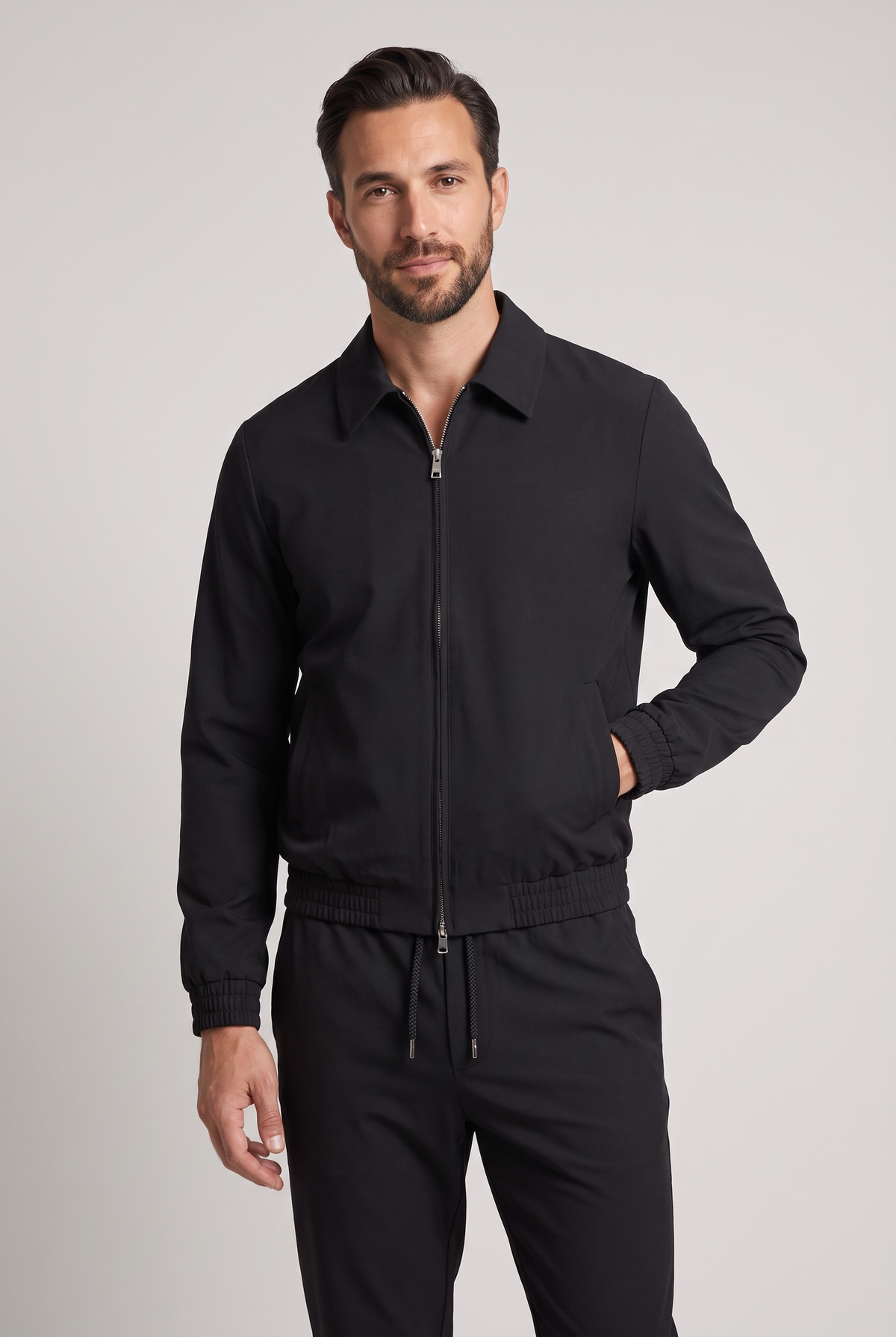 Astos tech suit zwart - model studio vooraanzicht, jack dicht