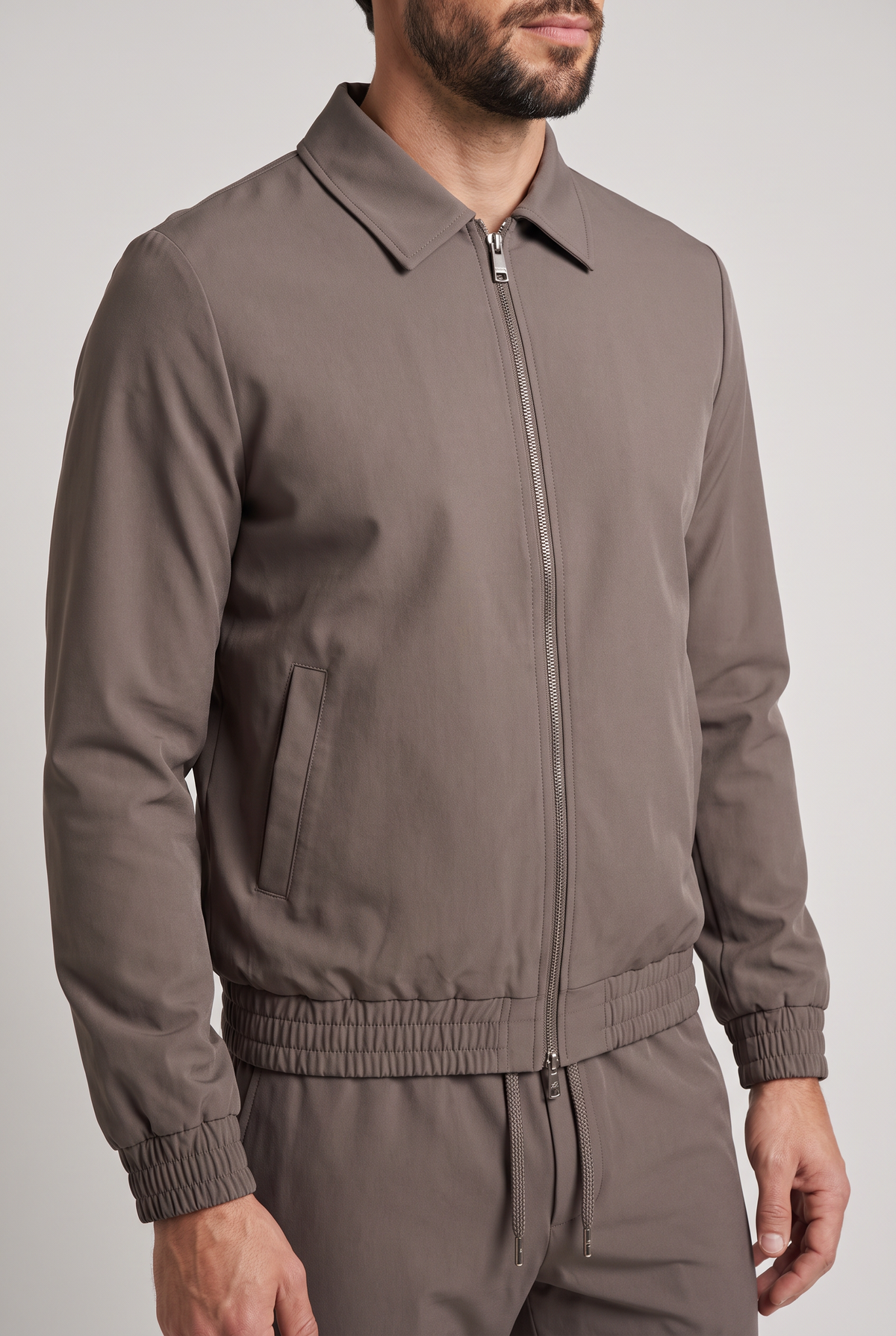 Astos tech suit bruin (taupe) - detail kraag, rits en elastische zoom