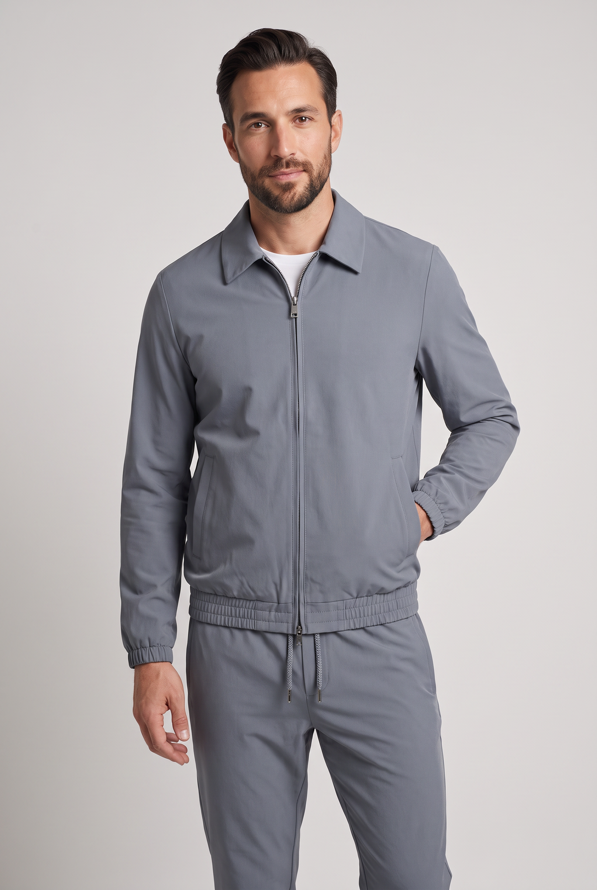 Astos tech suit grijs - model studio vooraanzicht, jack dicht