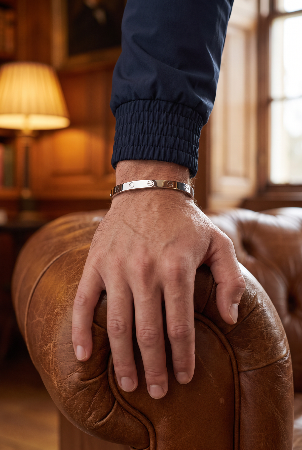 Astos screw armband zilver verguld - lifestyle close-up in de bibliotheek