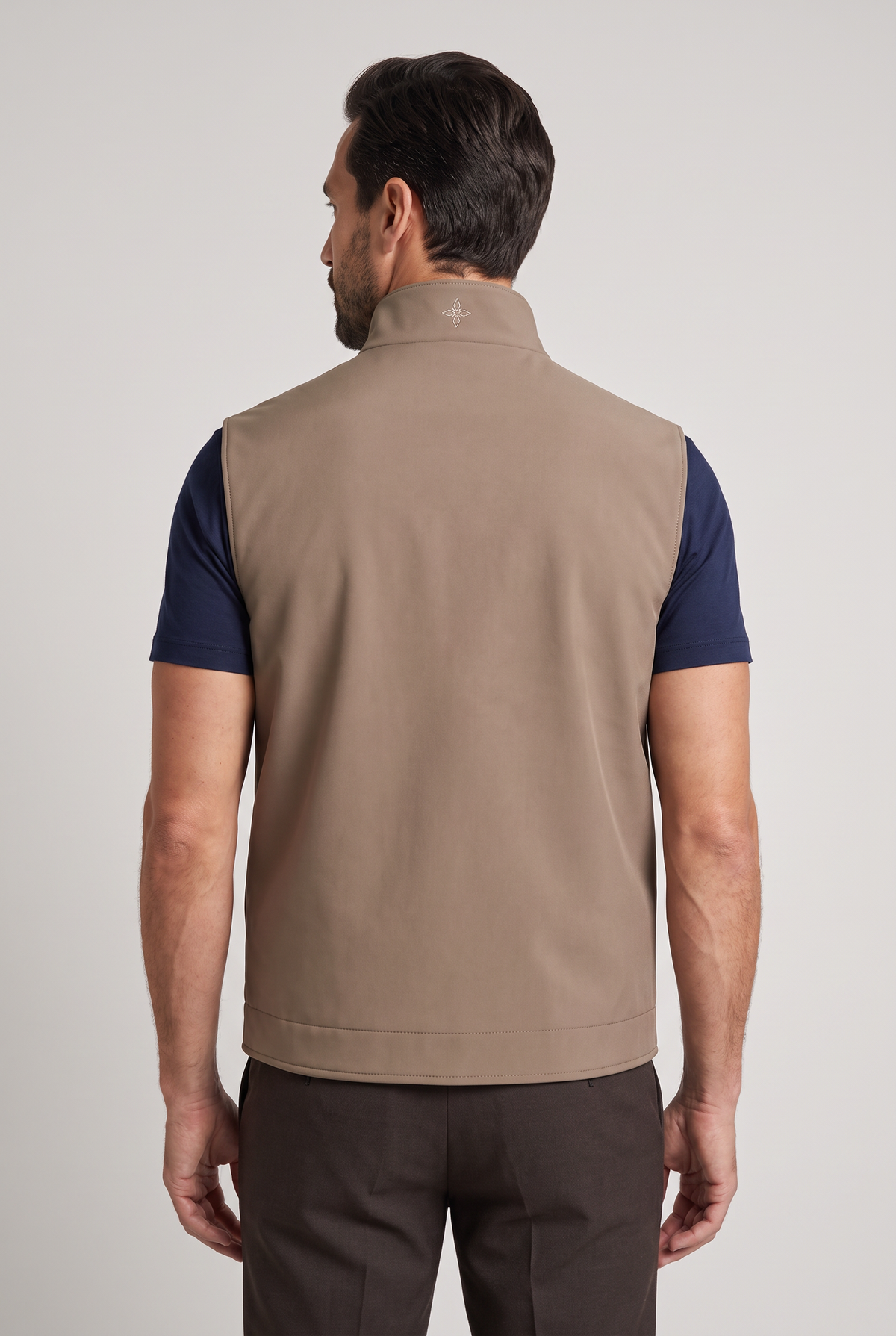 Tweezijdige bodywarmer beige - achteraanzicht met embleem op kraag, studio