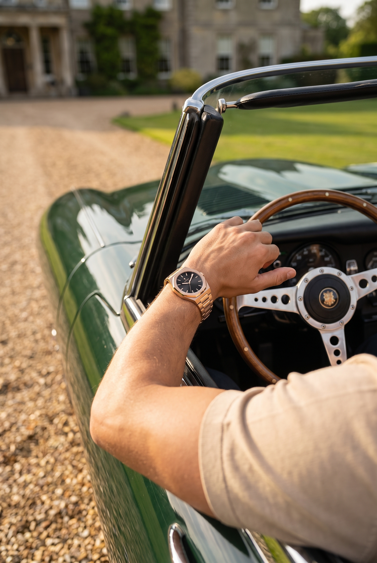ASTOS Royal Edition rosé goud - hand aan het stuur van een groene oldtimer bij landhuis